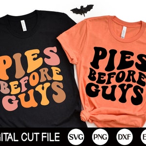 May include: Two t-shirts with the text "Pies Before Guys" in a retro font. The shirts are black and orange. The text is in black on the orange shirt and in orange, pink, and brown on the black shirt.