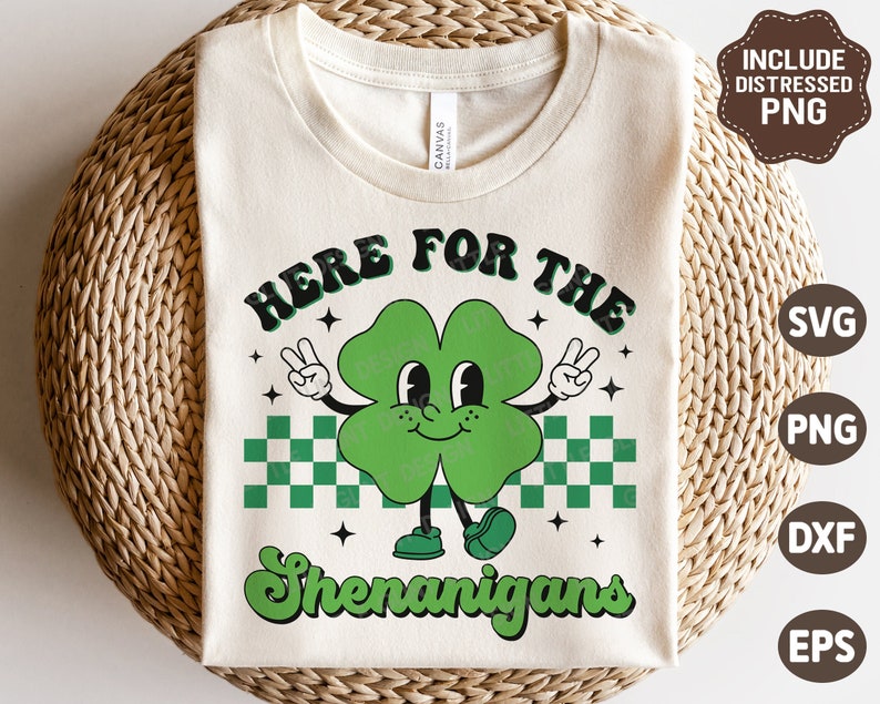 May include: A white t-shirt with a green shamrock character with the text "Here for the Shenanigans".
