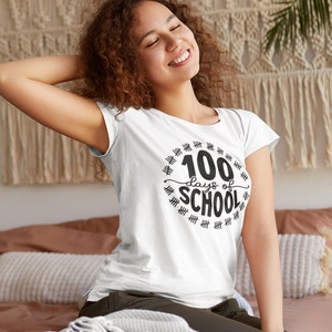 K&ouml;nnte beinhalten: Wei&szlig;es T-Shirt mit einer schwarzen Grafik, auf der "100 Tage Schule" steht, umgeben von Hashmarks.