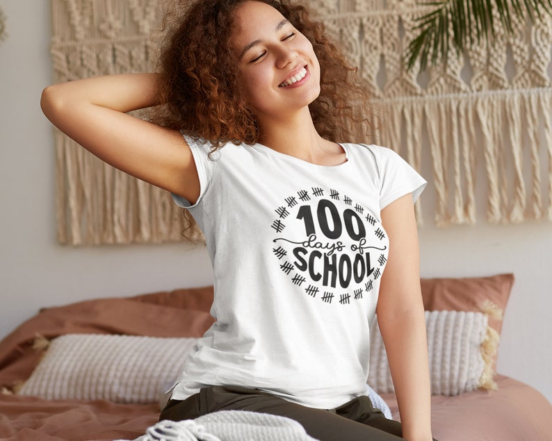 K&ouml;nnte beinhalten: Wei&szlig;es T-Shirt mit einer schwarzen Grafik, auf der "100 Tage Schule" steht, umgeben von Hashmarks.