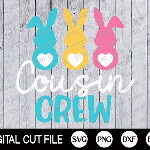 May include: A digital cut file design featuring three Easter bunny silhouettes in blue, yellow, and pink with white hearts. The text "Cousin Crew" is written in white and blue below the bunnies.