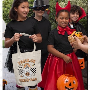 Pu&ograve; includere: Un gruppo di bambini vestiti con costumi di Halloween. Un bambino tiene una borsa di tela bianca con la scritta "Trick or Treat Bag" e un fantasma dei cartoni animati. Un altro bambino tiene un secchiello di dolcetto o scherzetto a forma di zucca.