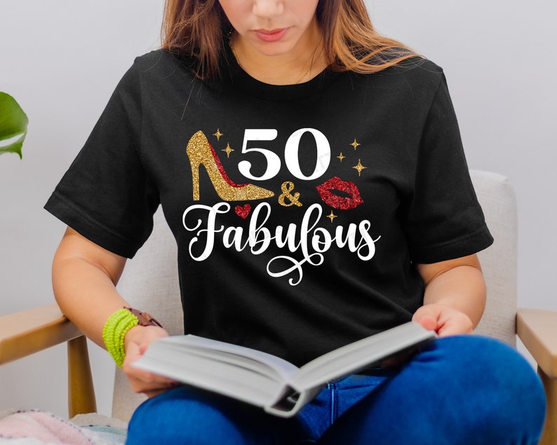 K&ouml;nnte beinhalten: Ein schwarzes T-Shirt mit goldfarbenem Glitzer-Schriftzug, auf dem "50 & Fabulous" steht, mit einem goldenen Glitzer-High-Heel-Schuh und einem roten Glitzer-Lippenabdruck.