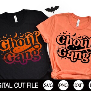 May include: Two t-shirts with the text "Ghoul Gang" in a retro font. The shirts are black and orange with a spider and stars graphic.
