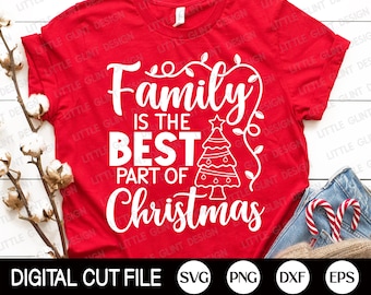 May include: Red t-shirt with white text that reads "Family is the best part of Christmas". A white outline of a Christmas tree with ornaments is to the right of the text. The t-shirt is on a white surface with a pair of jeans and candy canes.