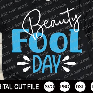 May include: A black t-shirt with the text "Beauty Fool Day" in white and blue lettering. The text "Beauty" is written in cursive.
