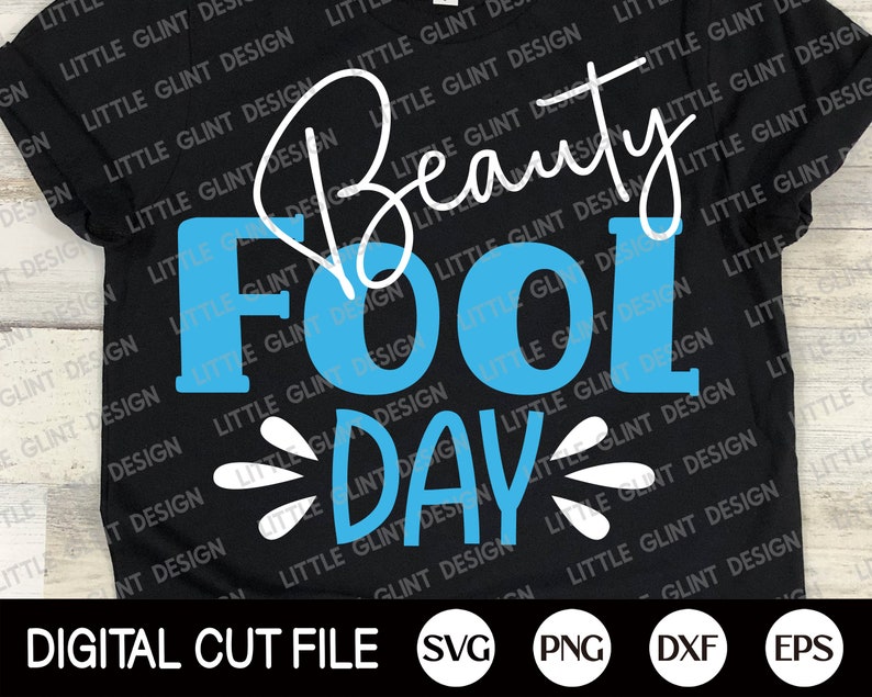 May include: A black t-shirt with the text "Beauty Fool Day" in white and blue lettering. The text "Beauty" is written in cursive.