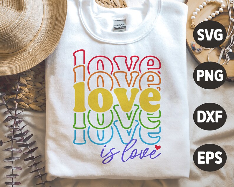 Puede incluir: Una sudadera blanca con un gr&aacute;fico de arco&iacute;ris que dice "love is love" con un peque&ntilde;o coraz&oacute;n rojo.