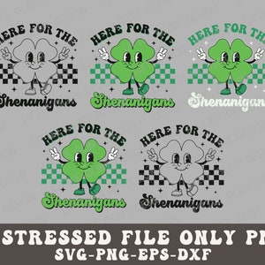 May include: A distressed green four-leaf clover with a smiling face and arms and legs, wearing shoes. The clover is holding up two fingers on each hand in a peace sign. The clover is standing on a checkered background with the text "HERE FOR THE SHENANIGANS" above and below it.