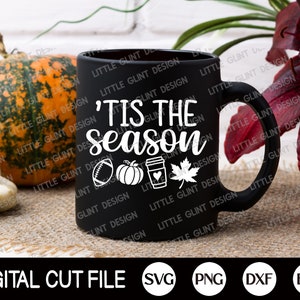May include: A black ceramic mug with the text "'Tis the season" and autumn-themed graphics, including a football, pumpkin, coffee cup, and maple leaf. The words "Digital Cut File" and file type icons are at the bottom.