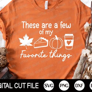 Puede incluir: Camiseta naranja con texto blanco que dice "These are a few of my favorite things". El texto está rodeado de imágenes de una calabaza, una rebanada de pastel, una hoja de arce y una taza de café.