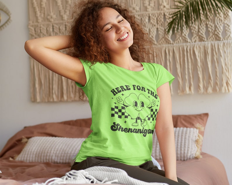 May include: A green t-shirt with a black graphic of a cartoon clover with the text "Here for the Shenanigans".