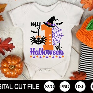 May include: White onesie with a purple and orange graphic of a spider, a witch's hat, and the text "my 1st Halloween".