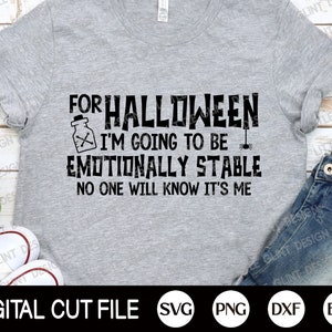 May include: A gray t-shirt with black text that reads "For Halloween I'm going to be emotionally stable. No one will know it's me."  The text is accompanied by a small image of a potion bottle and a spider.