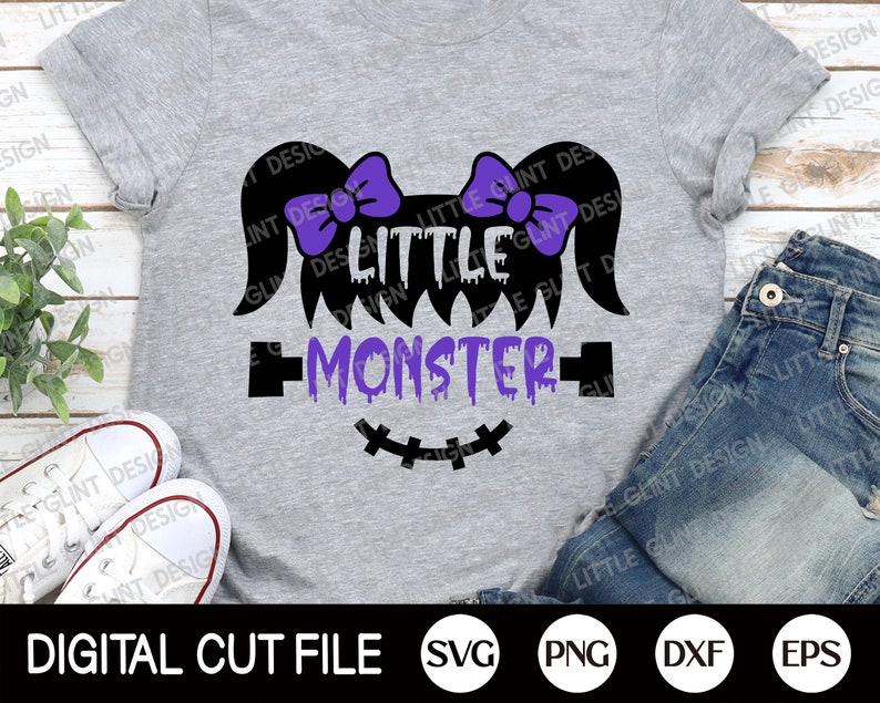 May include: A purple and black graphic design on a grey t-shirt that says "Little Monster" with dripping purple paint and a stitched-up mouth. The design includes two purple bows on top of the head.