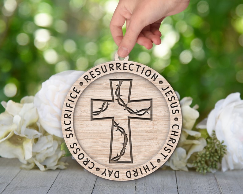 May include: A wooden round ornament with a cross design and the text "Third Day Cross Sacrifice Resurrection Jesus Christ" around the edge.