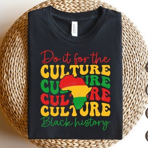 以下が含まれることがあります： 黒色のTシャツに「Do it for the CULTURE Black history」という文字が黄色、赤、緑の文字で書かれています。文字はレトロなフォントスタイルです。アフリカ大陸の輪郭がテキストの中央にあり、赤、黄色、緑で着色されています。