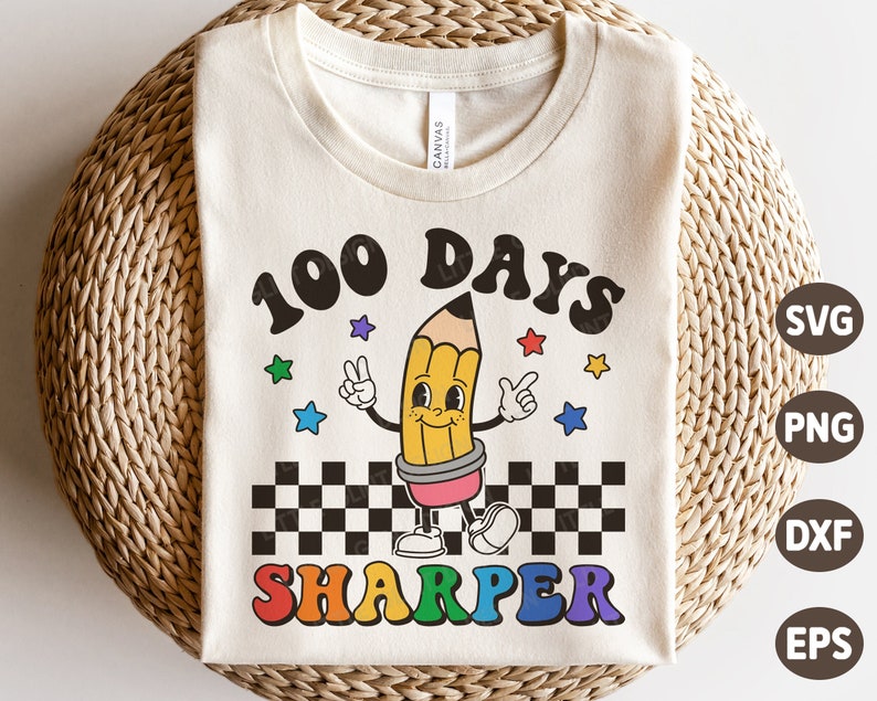 May include: A white t-shirt with a graphic design of a cartoon pencil with the text "100 Days Sharper" in rainbow colors. The design also includes a checkered pattern and stars.
