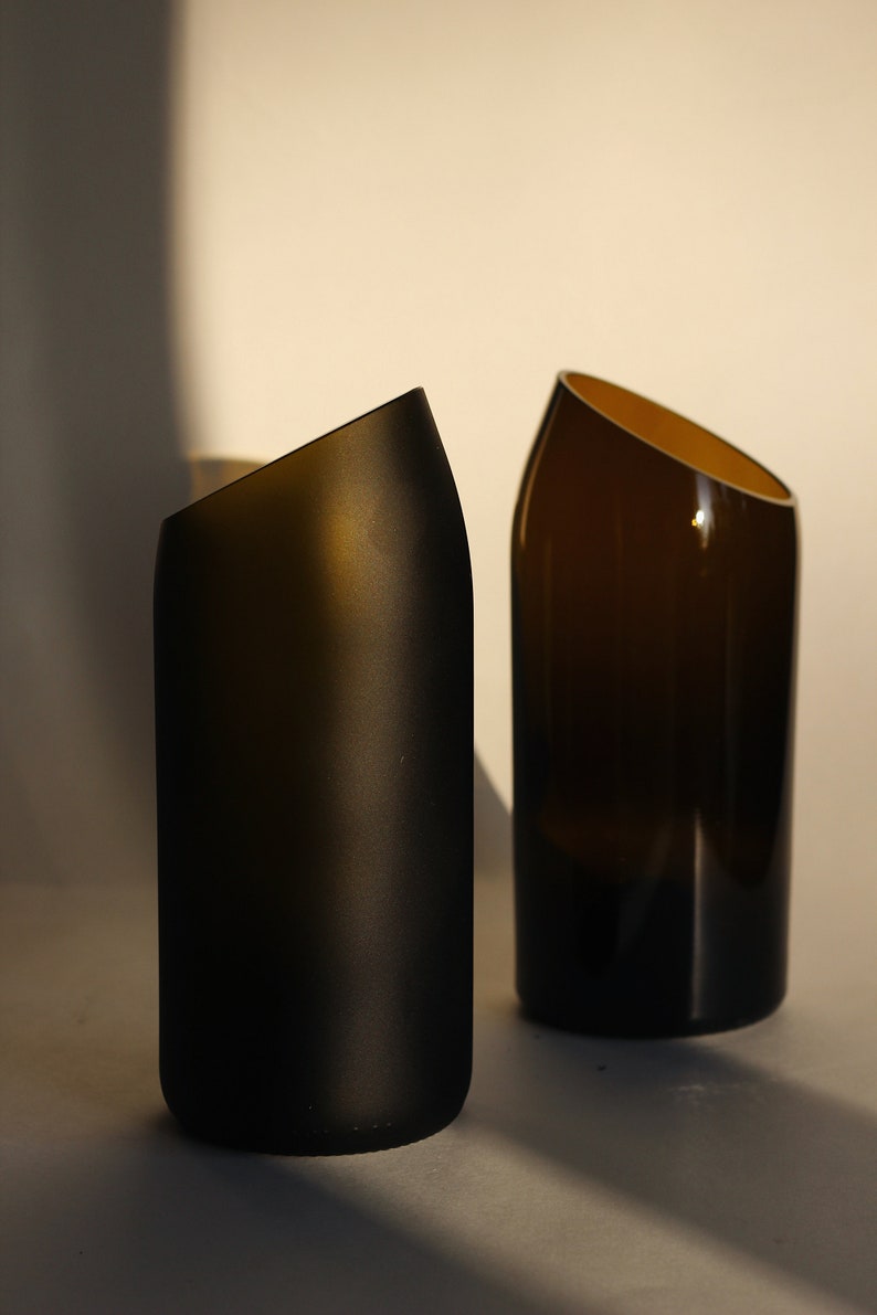 Pu&ograve; includere: Due vasi in vetro marrone scuro con un design angolare unico. Il vaso a sinistra &egrave; smerigliato, mentre il vaso a destra &egrave; trasparente.