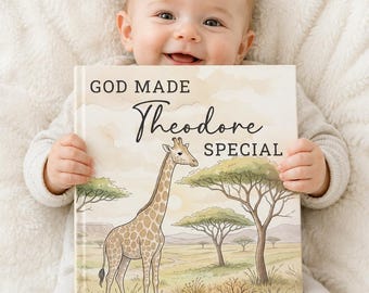 May include: A baby smiles while holding a personalized book. The book cover features a giraffe illustration in a savanna landscape, with the text "GOD MADE Theodore SPECIAL" in elegant script.