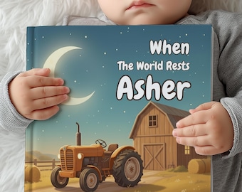 May include: A children's book titled "When The World Rests Asher" featuring a nighttime farm scene. The cover art depicts a yellow tractor, a barn, a crescent moon, and hay bales. The book is held by a baby.