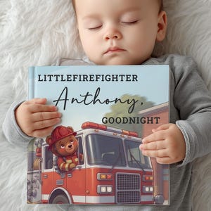 May include: A hardcover children's book titled LITTLEFIREFIGHTER Anthony, GOODNIGHT. The cover features an illustration of a brown bear wearing a red firefighter helmet and uniform, driving a red fire truck with a light blue sky background.