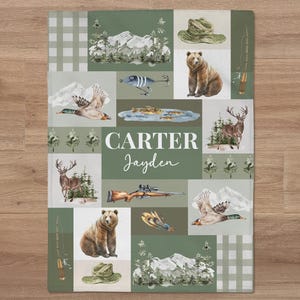 May include: A green and brown patchwork quilt with a hunting theme. The quilt features images of deer, ducks, fish, a rifle, and a bear. The quilt is personalized with the names "Carter" and "Jayden".