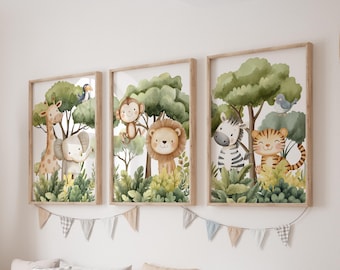 May include: Three framed watercolor prints featuring jungle animals: a giraffe, elephant, monkey, lion, zebra, and tiger. The artwork has a light wood frame and a garland of small flags hangs below the prints. The artwork is displayed on a white wall.