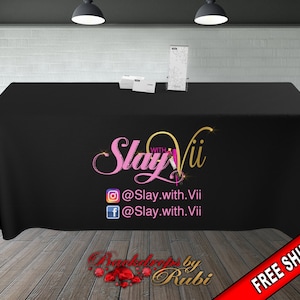 May include: Black table cover with a pink and gold logo that says "Slay withVii" and social media handles @Slay.with.Vii. The table cover also has the text "Backdrops by Rubi" and "FREE SHIPPING" in red.
