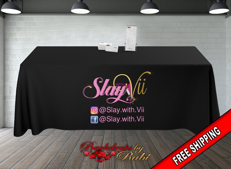 May include: Black table cover with a pink and gold logo that says "Slay withVii" and social media handles @Slay.with.Vii. The table cover also has the text "Backdrops by Rubi" and "FREE SHIPPING" in red.