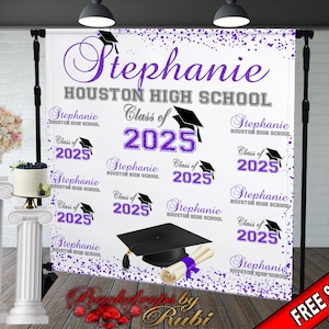 May include: Purple and white graduation backdrop with the text "Stephanie Houston High School Class of 2025". The backdrop is decorated with purple confetti and graduation caps.
