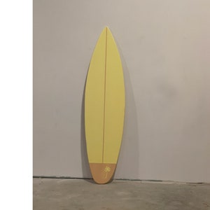 Houten surfplank wanddecoratie met honingraatmotief in vintage stijl.