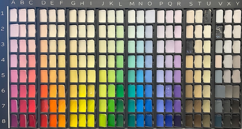 May include: A colour chart with 8 rows and 26 columns of small, square paint samples. The colours are arranged in a rainbow spectrum, starting with pink and ending with black. The chart is labelled with letters from A to X across the top and numbers from 1 to 8 down the side.
