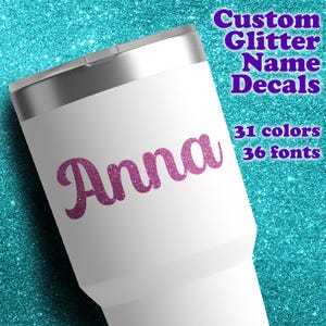 May include: A white tumbler with a metallic silver lid featuring the purple glitter name Anna in a cursive script. Text on the image reads Custom Glitter Name Decals, 31 colors, and 36 fonts against a bright teal glitter background.