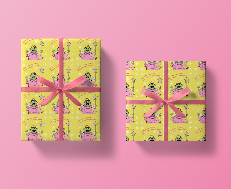 May include: Two yellow gift wrap rolls with a green character holding a pink wand and stars. The character is wearing a pink dress and has the text "Could she be any sweeter? What a wonderful girl!" repeated on the wrap.