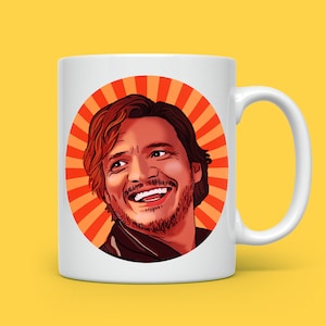 May include: White ceramic mug featuring a red and orange sunburst design. A cartoon illustration of a man with brown hair and a beard is smiling in the centre of the mug.