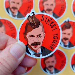 May include: A set of red and white round stickers with a cartoon illustration of a man with a mohawk and the text "Street Tough".