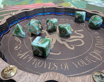 May include: A green and white marbled dice set with gold numbers on a wooden dice tray with an octopus design and the text "Cthulhu Approves of Your Rolls".