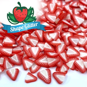 May include: A pile of red and white strawberry shaped glitter. The glitter is in the shape of a strawberry slice.