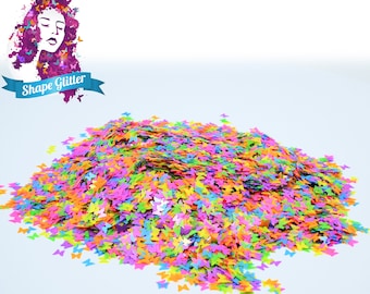 Könnte beinhalten: Ein großer Haufen bunter Schmetterlings-Glitzer. Der Glitzer ist eine Mischung aus Rosa, Orange, Gelb, Grün, Blau und Lila.