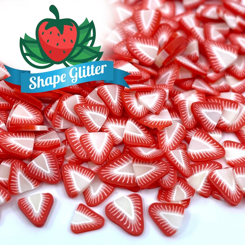May include: A pile of red and white strawberry shaped glitter. The glitter is in the shape of a strawberry slice.