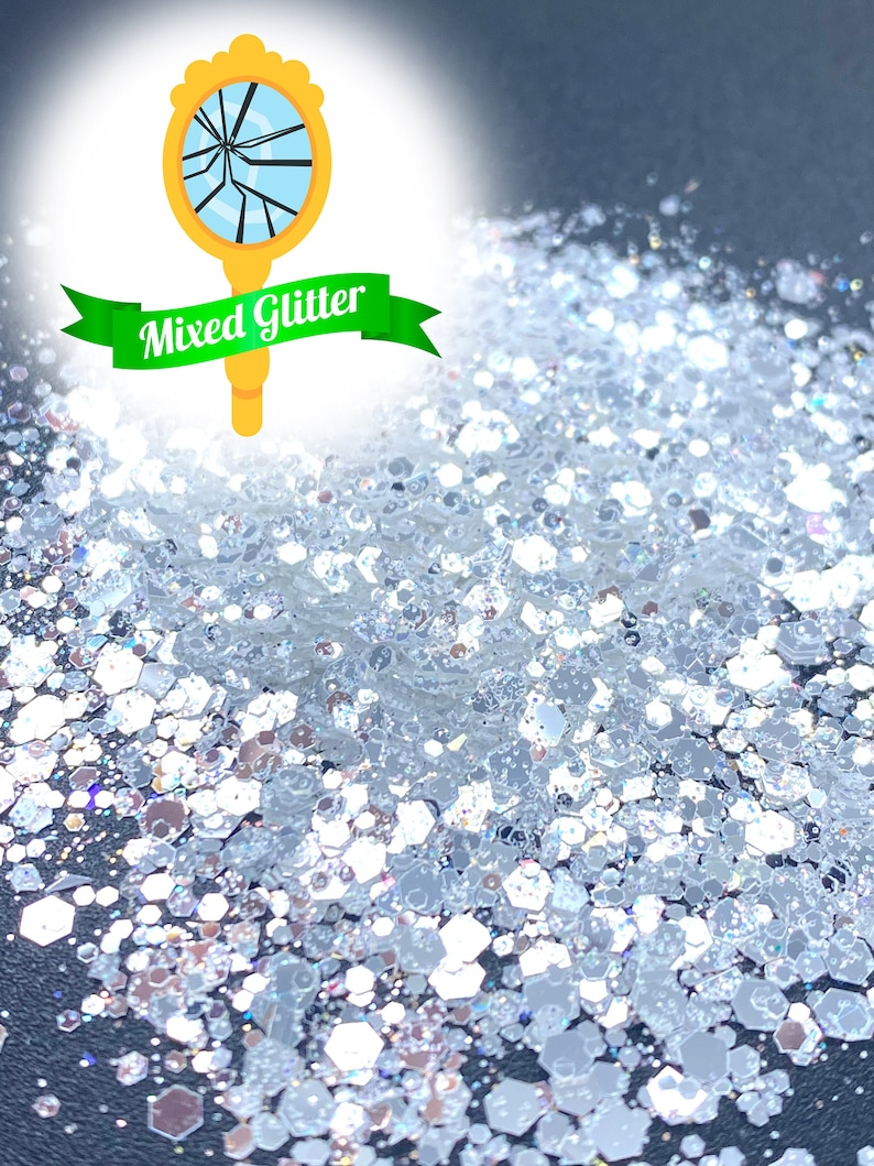 May include: A close-up of a pile of iridescent silver glitter. The glitter is a mix of different sizes and shapes, and it has a sparkly, reflective finish. The glitter is perfect for crafting, decorating, and adding a touch of sparkle to any project.