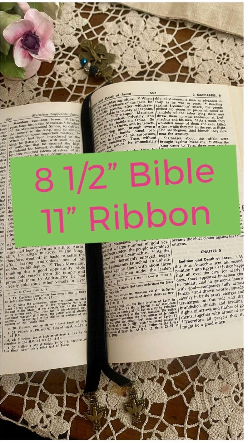 Pu&ograve; includere: Un segnalibro in pelle nera con un ciondolo a forma di colomba d'argento, una Bibbia di 8 1/2 pollici e un nastro di 11 pollici. La Bibbia &egrave; aperta al libro dei Maccabei, capitolo 5.