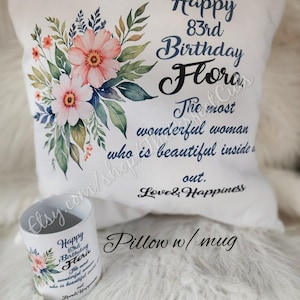 May include: White pillow and mug set with floral design and text. The pillow features a watercolor floral arrangement and the words "Happy 83rd Birthday Flora." The mug has a matching design. The set is a gift.