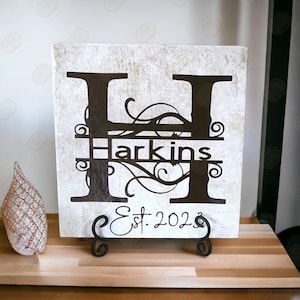 May include: A white square tile with a black letter H with decorative flourishes. The name "Harkins" is written in black across the center of the tile. The text "Est. 2023" is written in black at the bottom of the tile.