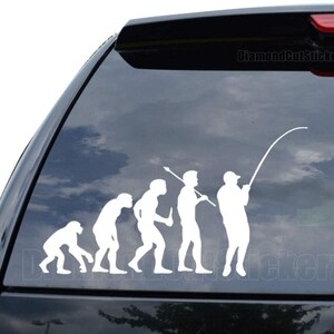 May include: A white vinyl decal of the evolution of man, ending with a man holding a fishing rod. The decal is on the back window of a black SUV. The text "DiamondCutStickerz" is visible in the top right corner of the image.