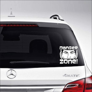 May include: White vinyl car sticker with a black and white illustration of a man's face and the text "Danger Zone!"