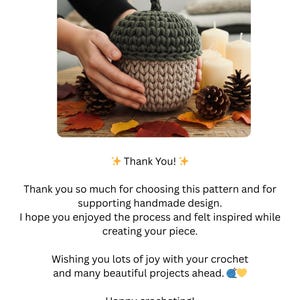 May include: A handmade crochet acorn in shades of green and tan, with a textured stitch pattern. The acorn is displayed on a wooden surface with autumn leaves and pine cones. The text "Thank You!" is also visible.