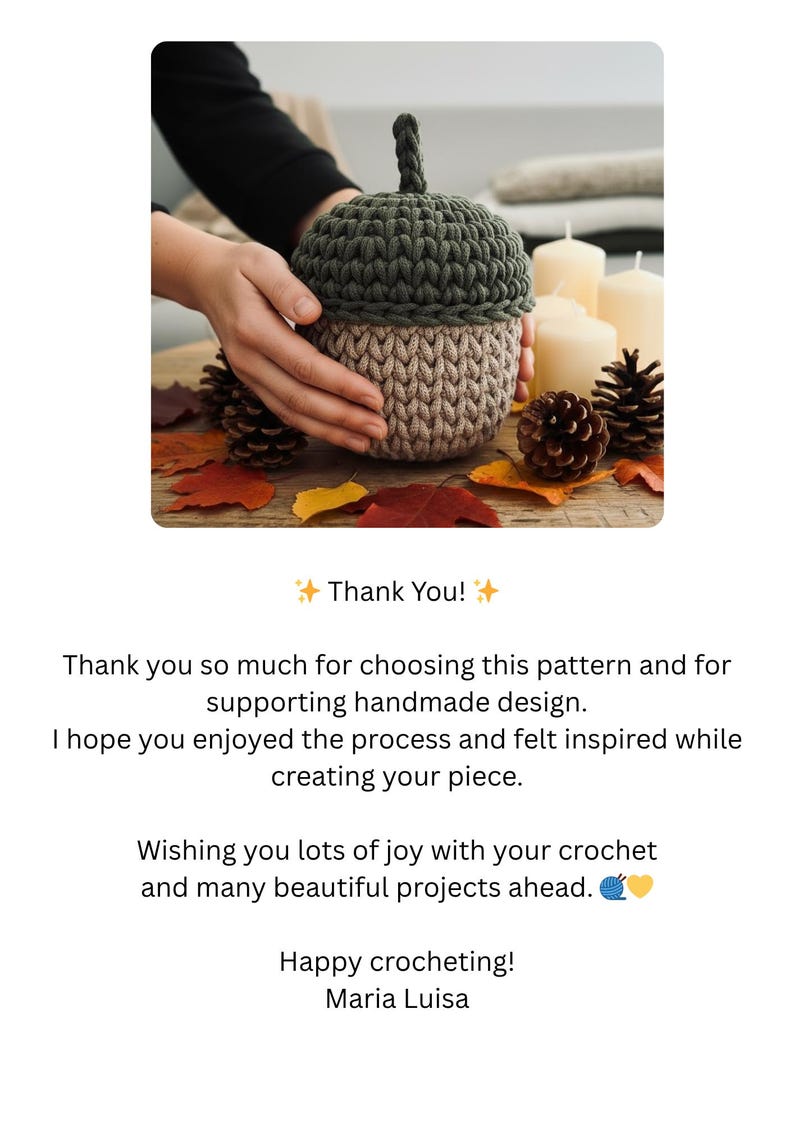 May include: A handmade crochet acorn in shades of green and tan, with a textured stitch pattern. The acorn is displayed on a wooden surface with autumn leaves and pine cones. The text "Thank You!" is also visible.