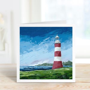 May include: A square greeting card featuring a painting of a lighthouse. The lighthouse is red and white striped, set against a blue sky with white clouds. Green grass and the ocean are in the foreground.